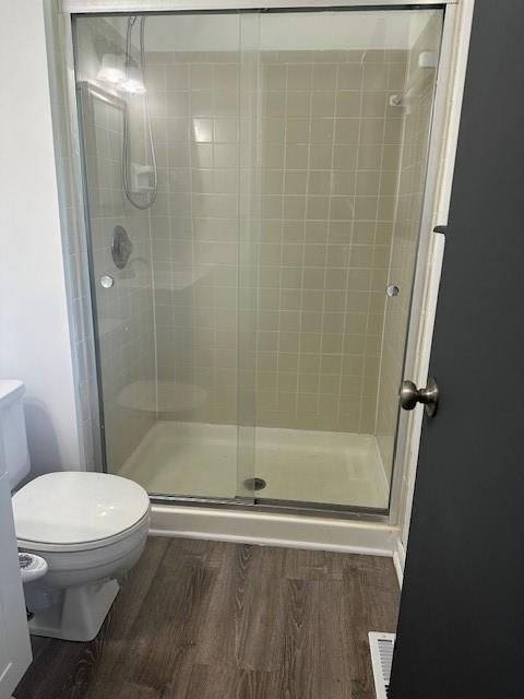 7037 N Holmes St, Gladstone, MO 64118 - full bath featuring toilet, wood finished floors, and a shower stall