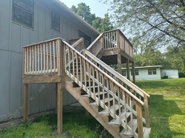 7037 N Holmes St, Gladstone, MO 64118 - wooden terrace featuring stairway and a yard