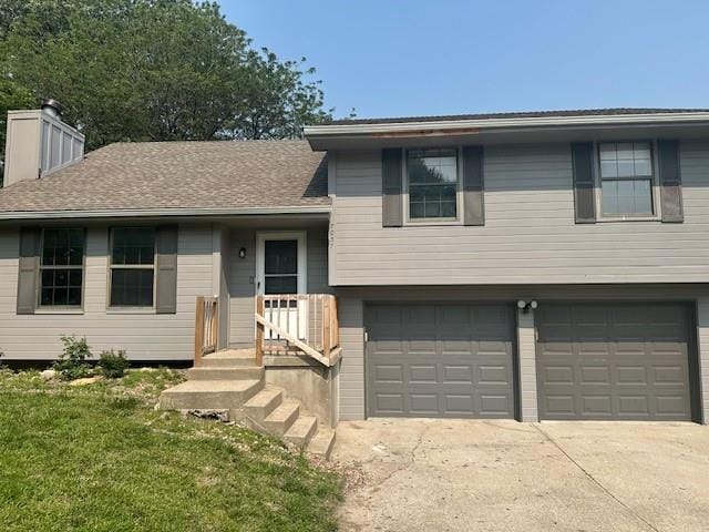 7037 N Holmes St, Gladstone, MO 64118 - split level home with an attached garage, driveway, a chimney, and a front yard