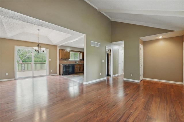 unfurnished living room featuring lofted ceiling, a chandelier, wood finished floors, and baseboards