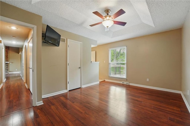 spare room featuring ceiling fan, hardwood / wood-style flooring, a textured ceiling, and baseboards