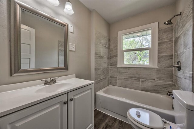 504 12th St, Osawatomie, KS 66064 - full bathroom featuring wood finished floors, vanity, shower / washtub combination, and toilet
