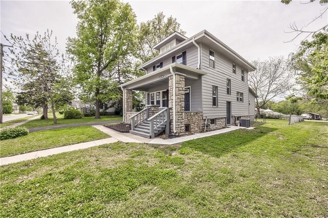 504 12th St, Osawatomie, KS 66064 - traditional style home featuring central AC, a front yard, and stone siding