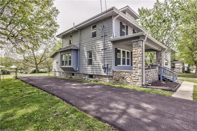 view of side of property with driveway and a yard
