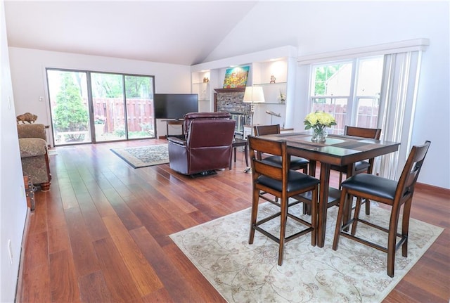 2218 Condolea Ter, Leawood, KS 66209 - dining space with healthy amount of natural light, wood finished floors, high vaulted ceiling, and a stone fireplace