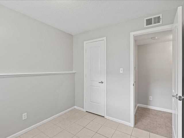 310-312 N 8th St, Leavenworth, KS 66048 - empty room featuring a textured ceiling, light tile patterned floors, and baseboards