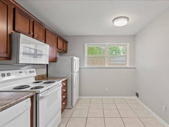 310-312 N 8th St, Leavenworth, KS 66048 - kitchen featuring white appliances, baseboards, a textured ceiling, and light tile patterned floors