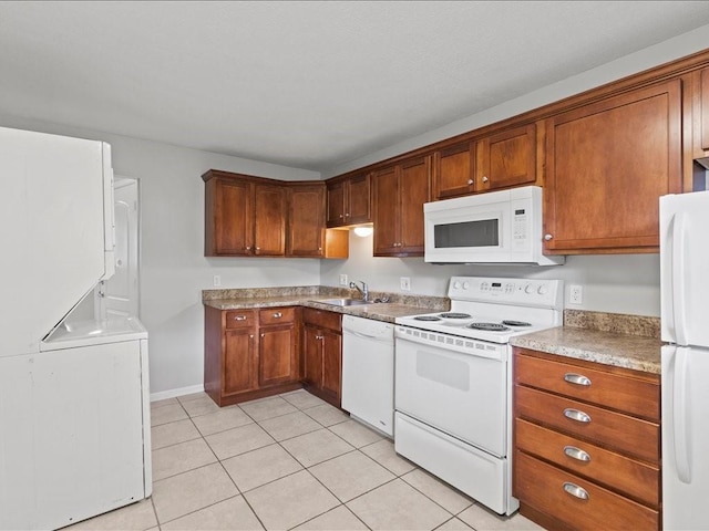 310-312 N 8th St, Leavenworth, KS 66048 - kitchen with white appliances, stacked washer / dryer, light tile patterned flooring, a sink, and brown cabinets