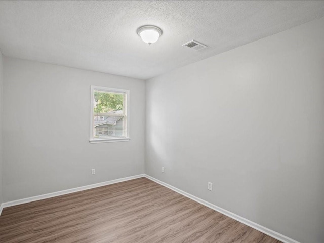310-312 N 8th St, Leavenworth, KS 66048 - empty room featuring wood finished floors, a textured ceiling, and baseboards