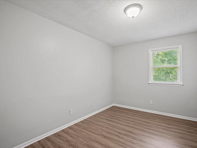 310-312 N 8th St, Leavenworth, KS 66048 - empty room featuring wood finished floors, baseboards, and a textured ceiling