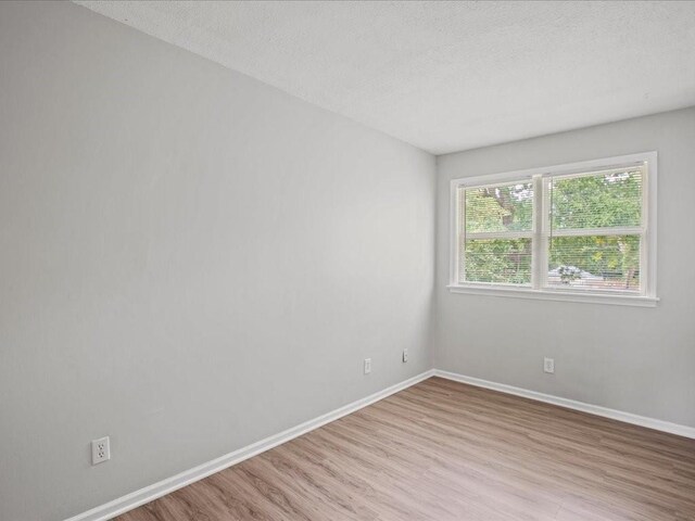 310-312 N 8th St, Leavenworth, KS 66048 - empty room with wood finished floors, baseboards, and a textured ceiling