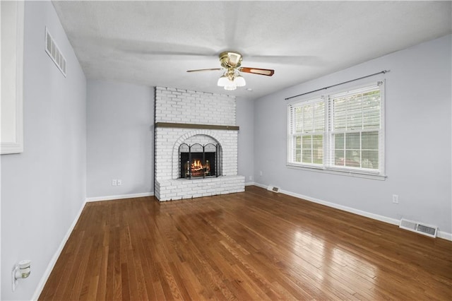 1608 SE Hillside Dr, Oak Grove, MO 64075 - unfurnished living room with ceiling fan, a brick fireplace, wood finished floors, and baseboards
