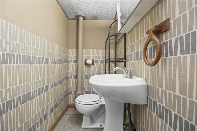 1608 SE Hillside Dr, Oak Grove, MO 64075 - bathroom with tile walls, tile patterned flooring, toilet, and wainscoting