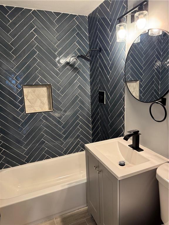 4715 E 45th St, Kansas City, MO 64130 - full bathroom featuring vanity, shower / washtub combination, and toilet