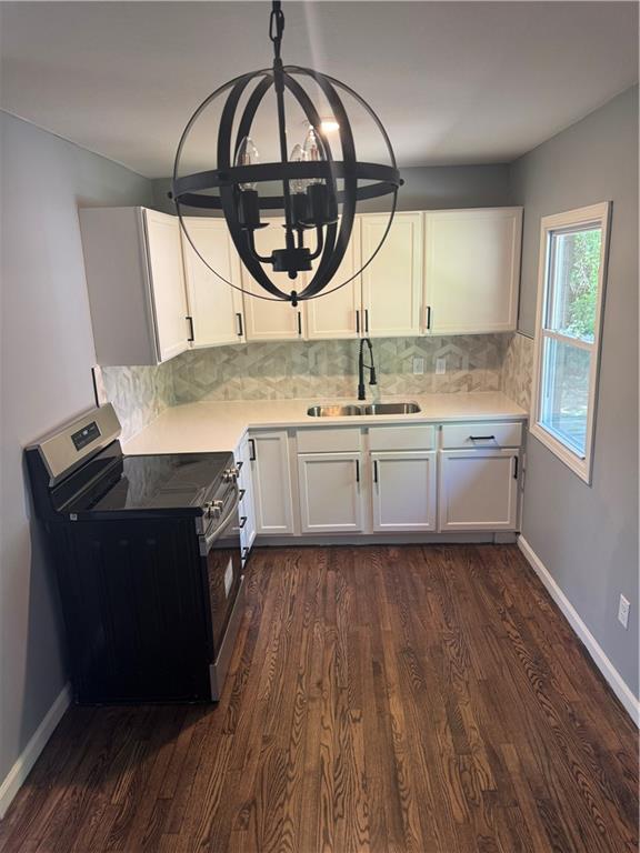 4715 E 45th St, Kansas City, MO 64130 - kitchen with stainless steel range with electric cooktop, a sink, dark wood-style floors, and white cabinetry