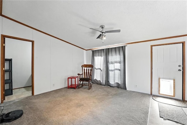 39460 Indianapolis Rd, Lane, KS 66042 - empty room featuring crown molding, a ceiling fan, vaulted ceiling, carpet floors, and a textured ceiling