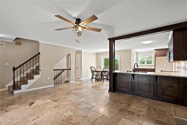 21815 W 73rd Ter, Shawnee, KS 66218 - kitchen with stone tile flooring, dark brown cabinets, baseboards, a ceiling fan, and ornamental molding