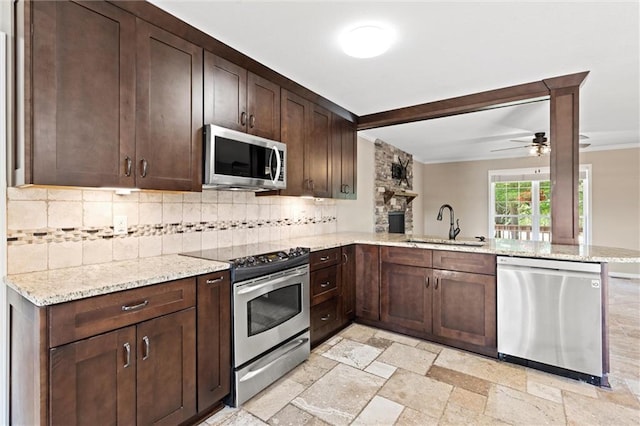21815 W 73rd Ter, Shawnee, KS 66218 - kitchen featuring appliances with stainless steel finishes, a sink, backsplash, a peninsula, and ornamental molding