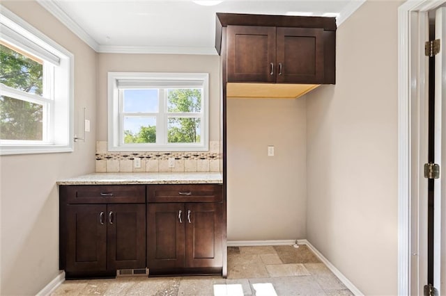 21815 W 73rd Ter, Shawnee, KS 66218 - laundry area with healthy amount of natural light, baseboards, ornamental molding, and light stone finish flooring