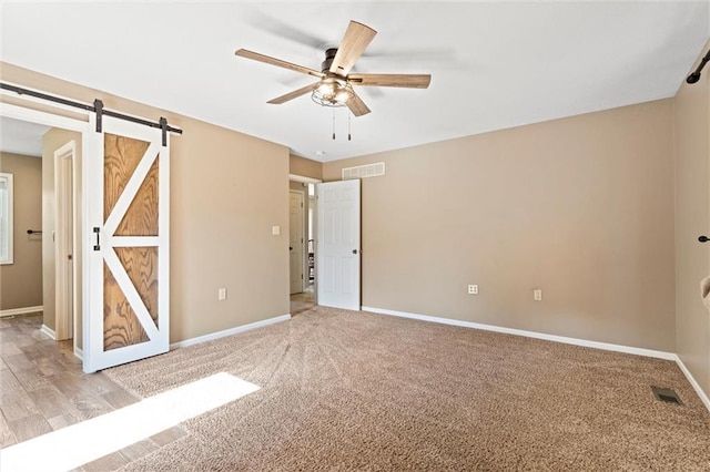 21815 W 73rd Ter, Shawnee, KS 66218 - unfurnished bedroom with baseboards, a barn door, light colored carpet, and a ceiling fan