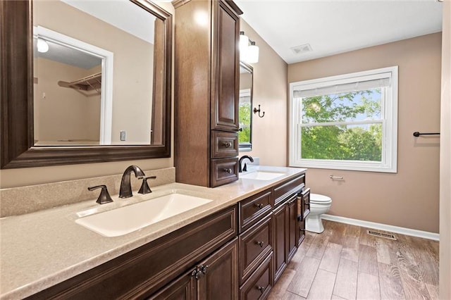 21815 W 73rd Ter, Shawnee, KS 66218 - full bathroom with double vanity, toilet, baseboards, and wood finished floors