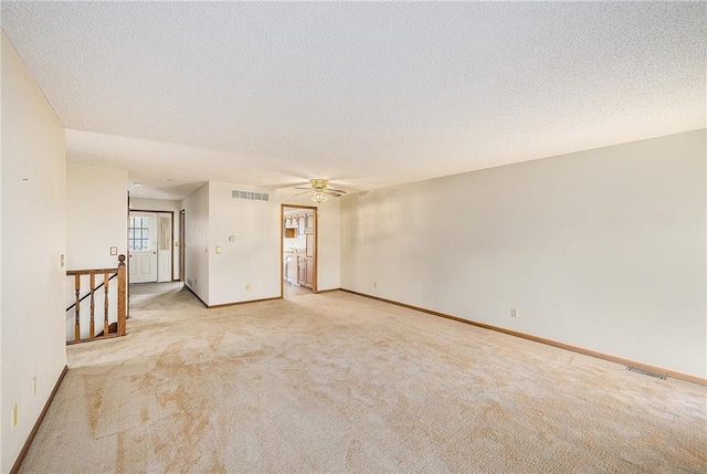 empty room with carpet floors, a ceiling fan, baseboards, and a textured ceiling