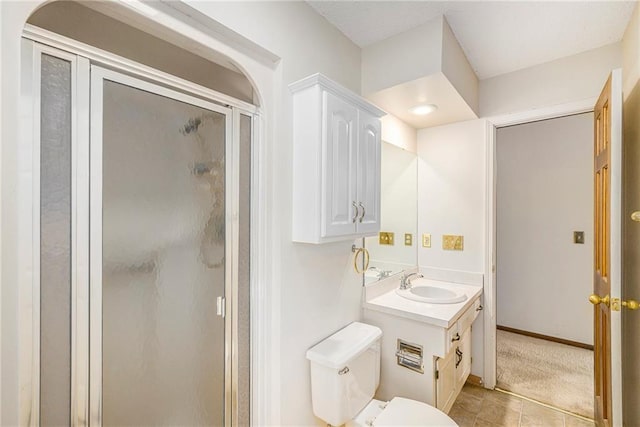 full bathroom featuring a shower stall, toilet, vanity, tile patterned flooring, and baseboards