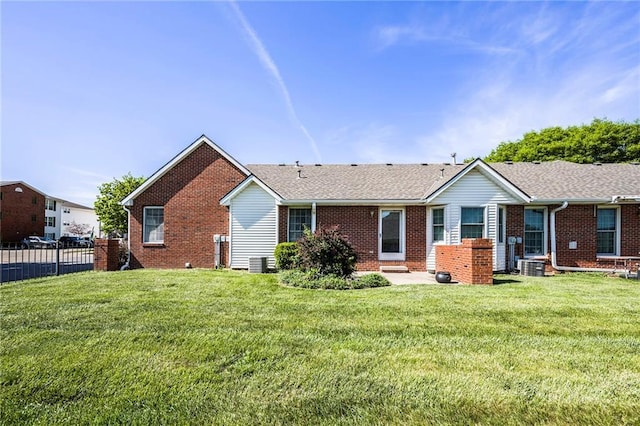 rear view of house featuring brick siding and central AC