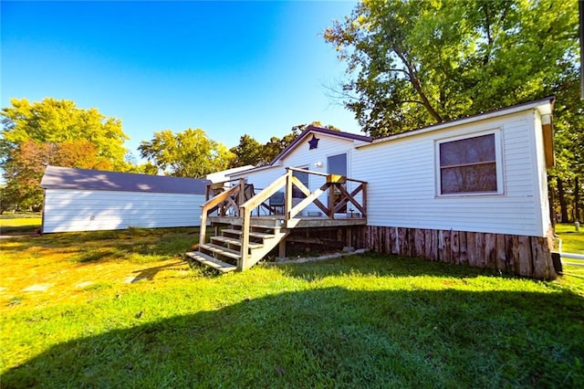 back of house with a wooden deck and a lawn