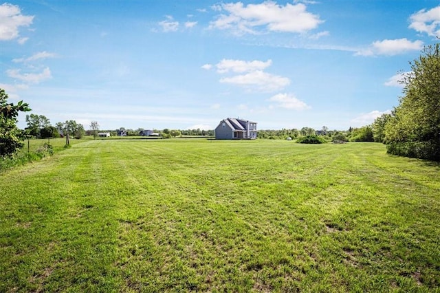 view of green lawn featuring a rural view