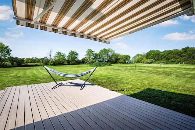 wooden terrace with a yard and view of wooded area