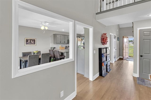 corridor featuring light wood-style floors and baseboards