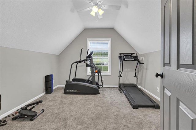 exercise room featuring ceiling fan, baseboards, vaulted ceiling, carpet floors, and a textured ceiling