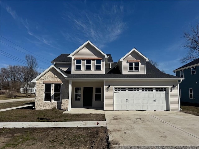 305 N Prairie St, Hamilton, MO 64644 - view of front of home with an attached garage, covered porch, concrete driveway, and stone siding