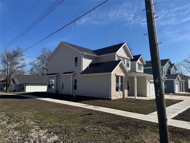 305 N Prairie St, Hamilton, MO 64644 - view of home's exterior with stone siding, driveway, a lawn, and a residential view