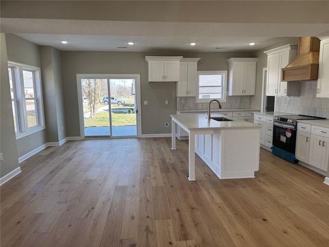 305 N Prairie St, Hamilton, MO 64644 - kitchen featuring stainless steel range with electric stovetop, custom exhaust hood, a sink, light countertops, and recessed lighting