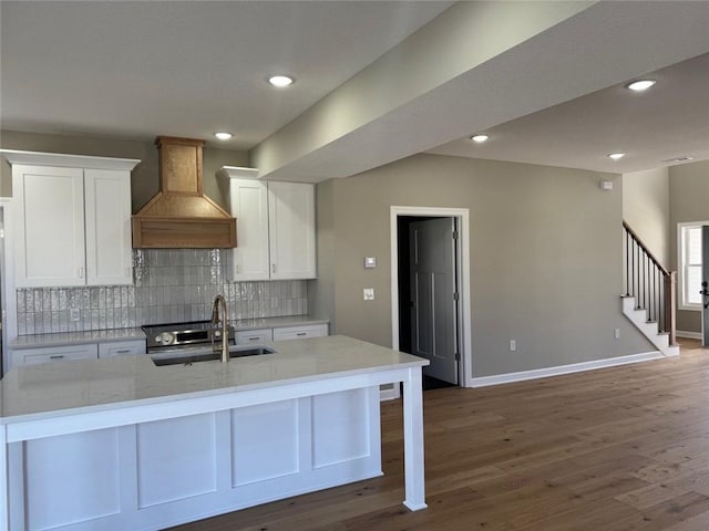 305 N Prairie St, Hamilton, MO 64644 - kitchen with a sink, premium range hood, white cabinets, backsplash, and recessed lighting