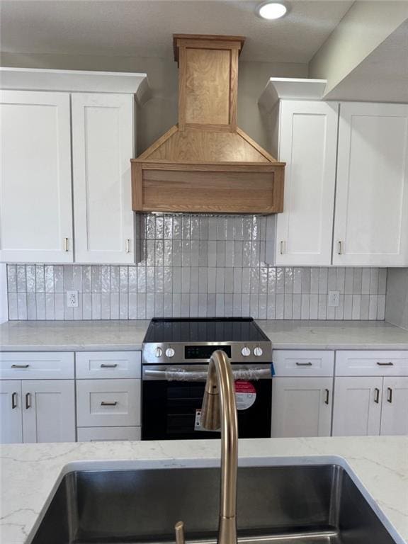 305 N Prairie St, Hamilton, MO 64644 - kitchen featuring electric range, custom exhaust hood, white cabinetry, and tasteful backsplash