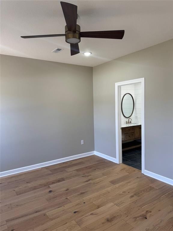 305 N Prairie St, Hamilton, MO 64644 - unfurnished bedroom featuring baseboards, wood finished floors, and ensuite bathroom
