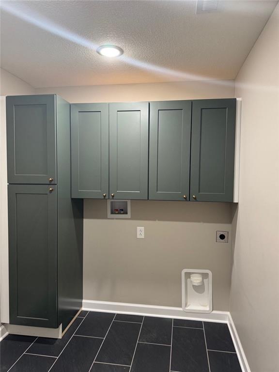 305 N Prairie St, Hamilton, MO 64644 - laundry area featuring electric dryer hookup, washer hookup, cabinet space, baseboards, and a textured ceiling