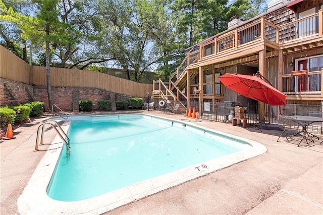 community pool featuring stairway and a patio