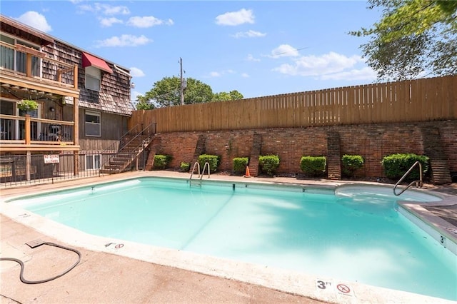 community pool featuring a fenced backyard