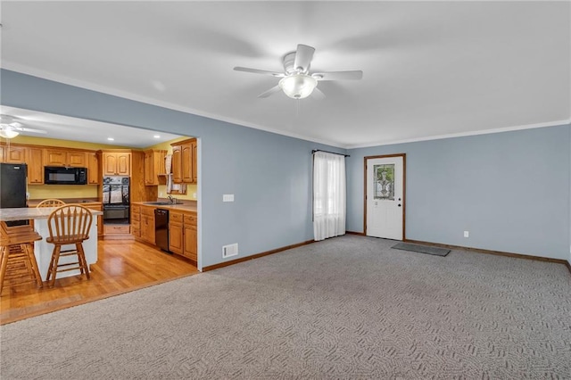 living room with a ceiling fan, crown molding, baseboards, and light carpet