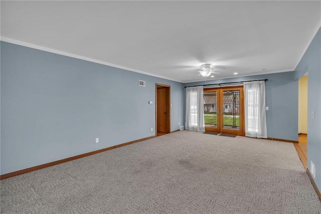 carpeted spare room with baseboards, ornamental molding, and a ceiling fan