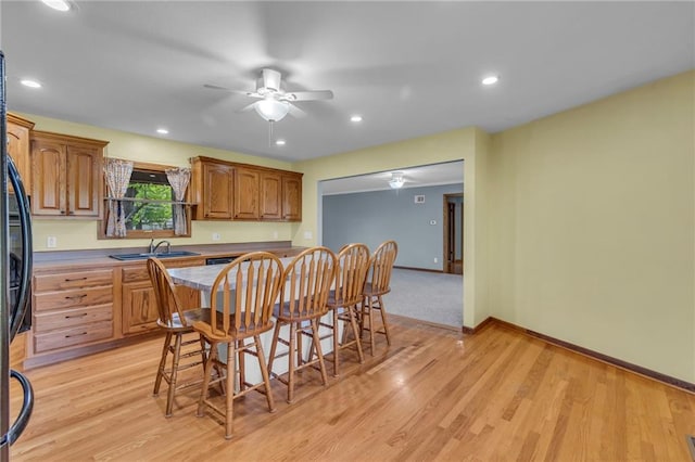 kitchen with a sink, ceiling fan, light wood-style floors, baseboards, and recessed lighting