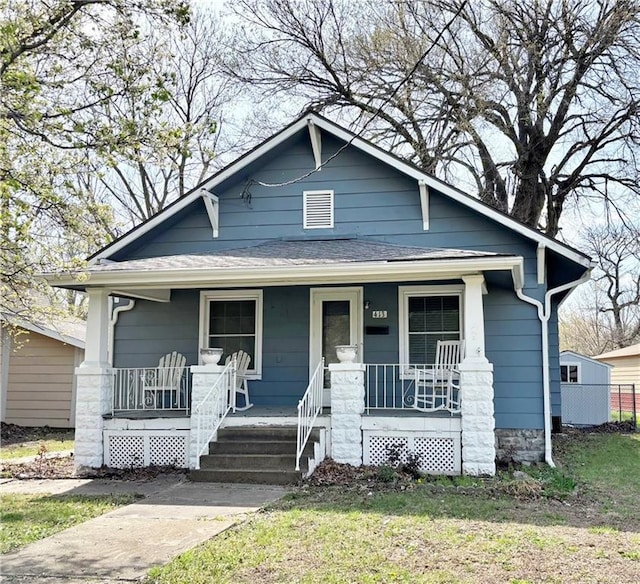 bungalow featuring covered porch and roof with shingles