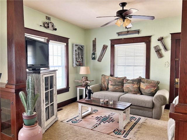 living area with carpet and ceiling fan
