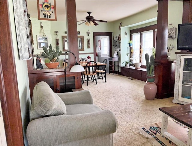 carpeted living area with ceiling fan