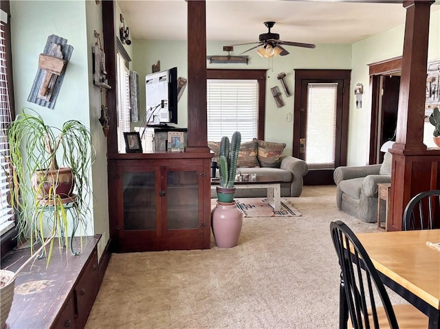 living room featuring carpet floors, ornate columns, and a ceiling fan
