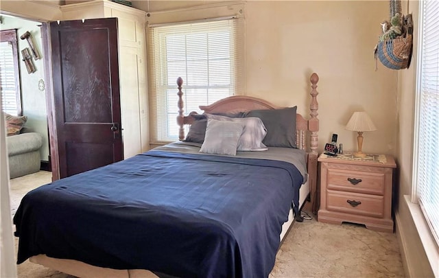 bedroom with light carpet and multiple windows